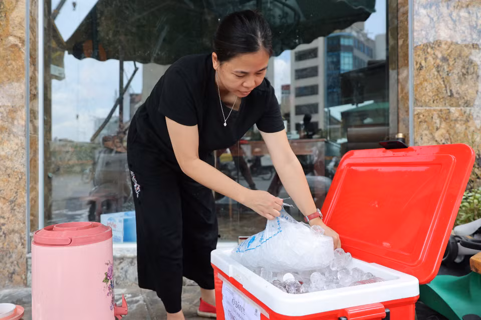 Chị không cho đá trực tiếp vào nước mà đóng chai sau đó ủ đá cho mát vì sợ đá không sạch sẽ. (Ảnh: Hoài Nam/Vietnam+)