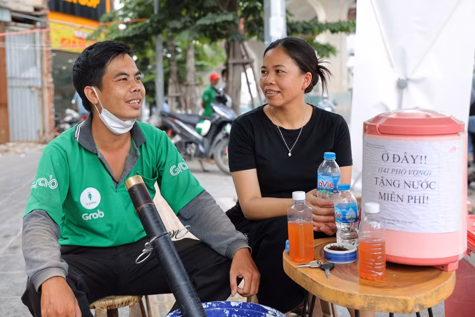 Anh Thịnh chạy xe ôm, thường xuyên phải di chuyển ngoài đường lúc nắng nóng, tâm sự: 'Đây là việc thiện, tôi cảm thấy rất phấn khởi khi có những người như gia đình chị Hương.' (Ảnh: Hoài Nam/Vietnam+)