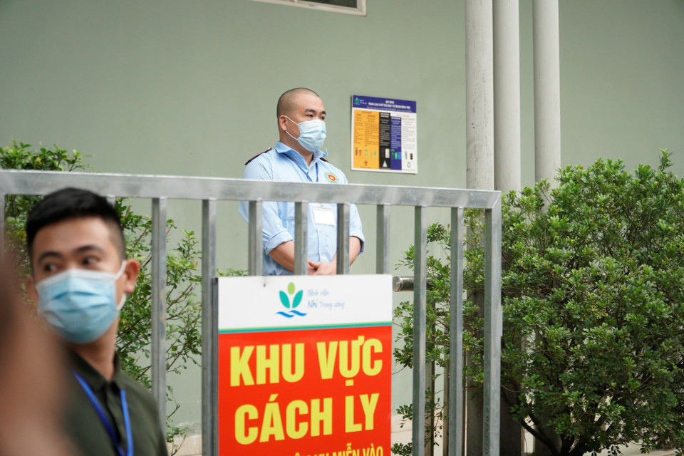 Lực lượng bảo vệ tại khu vực đưa bé L ra xe. (Ảnh: Minh Hiếu/Vietnam+)