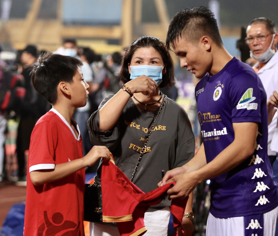 Quang Hải ký tặng em nhỏ hâm mộ và ăn mừng với mẹ. Tiền vệ số 19 ghi bàn quyết định ở trận chung kết trước Viettel bằng pha vô-lê đẳng cấp. (Ảnh: Hiển Nguyễn/Vietnam+)