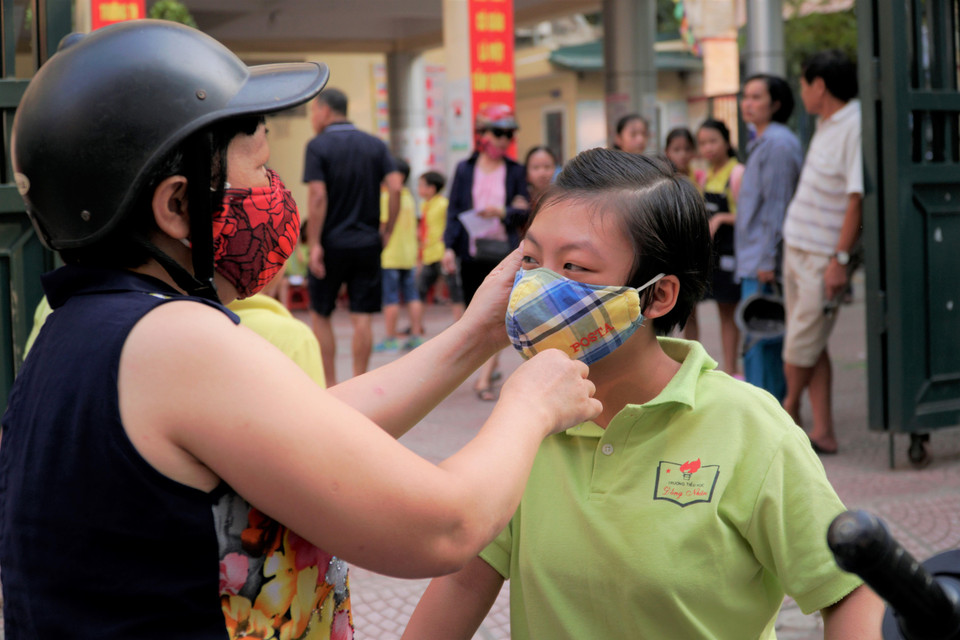 Việc đeo khẩu trang cho các trẻ nhỏ là rất cần thiết. (Ảnh: Minh Hiếu/Vietnam+)