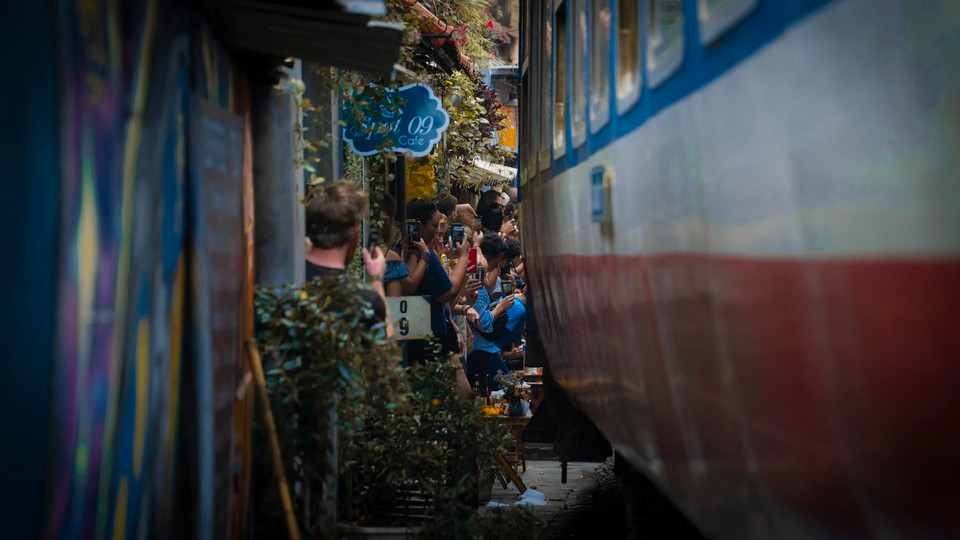 Vỉa hè bên hai bên đường chỉ cách con tàu chạy qua vài chục centimet. (Ảnh: Minh Hiếu/Vietnam+)