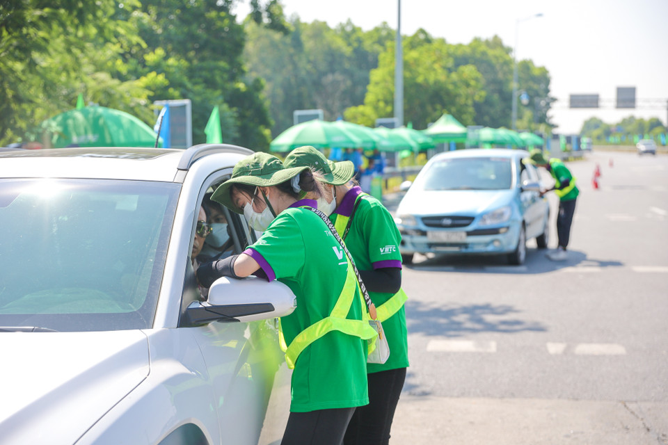 Một số xe chưa dán thẻ ETC đã được các nhân viên tại trạm phục vụ ngay tại chỗ. Các trường hợp không đủ tiền được nhân viên hướng dẫn qua trạm và nạp tiền vào tài khoản để đủ điều kiện lưu thông. (Ảnh: Minh Sơn/Vietnam+)