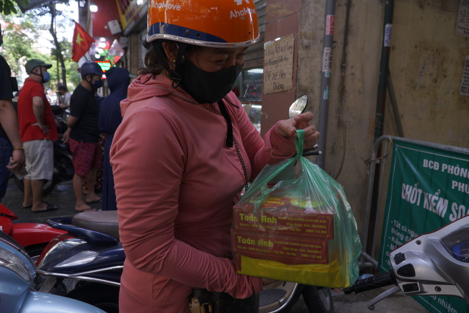 Chị P. (Gia Lâm, Hà Nội) cho biết chị phải xếp hàng gần 30 phút đồng hồ để mua được bánh. (Ảnh: Minh Hiếu/Vietnam+)