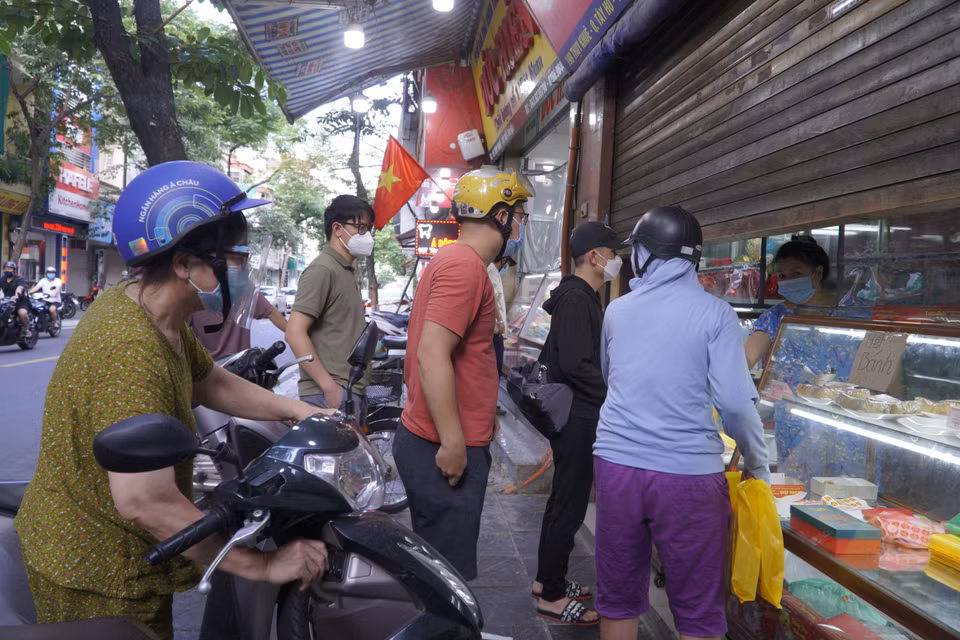 Người xếp hàng mua san sát, không thực hiện giãn cách tối thiểu 2m. (Ảnh: Minh Hiếu/Vietnam+)