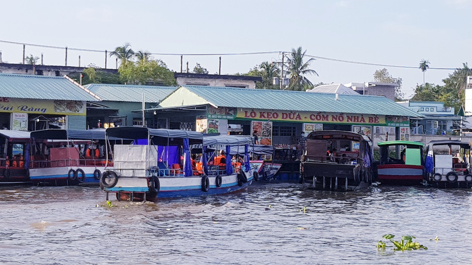 Lò kẹo dừa, cốm nổ trên chợ nổi. (Ảnh: Vietnam+)