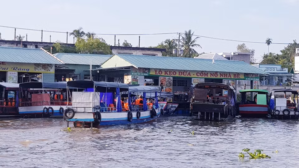 Lò kẹo dừa, cốm nổ trên chợ nổi. (Ảnh: Vietnam+)