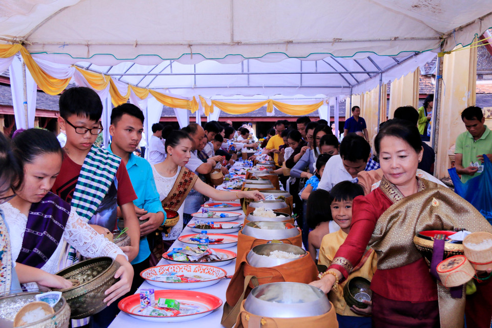 Các phật tử đang thực hiện nghi thức Xaybath để dâng đồ lễ cho các nhà sư và cho những người đã khuất tại 1 ngôi chùa ở thủ đô Viêng Chăn vào sáng 13/10. (Ảnh: Phạm Kiên/TTXVN)