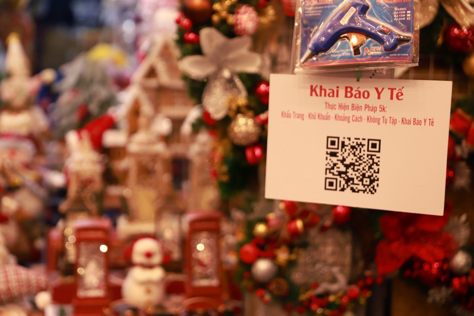 Cửa hàng nào cũng treo biển QR code và nhắc nhở người dân khi đến mua sắm thực hiện tốt 5K. (Ảnh: Hoài Nam/Vietnam+)
