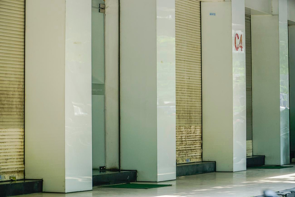 Tuy vẫn duy trì hoạt động nhưng cửa hàng chỉ mở duy nhất lối ra vào, các ô còn lại bị đóng. (Ảnh: Minh Hiếu/Vietnam+)