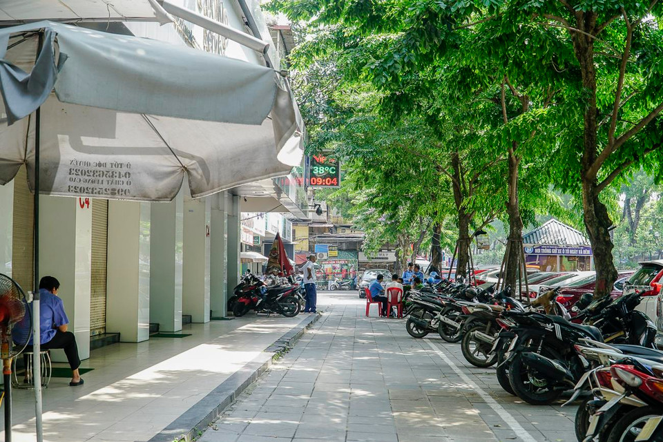 Bảo vệ của cửa hàng trông và dắt xe gọn gàng trên vỉa hè, đảm bảo an ninh trật tự công cộng. (Ảnh: Minh Hiếu/Vietnam+)