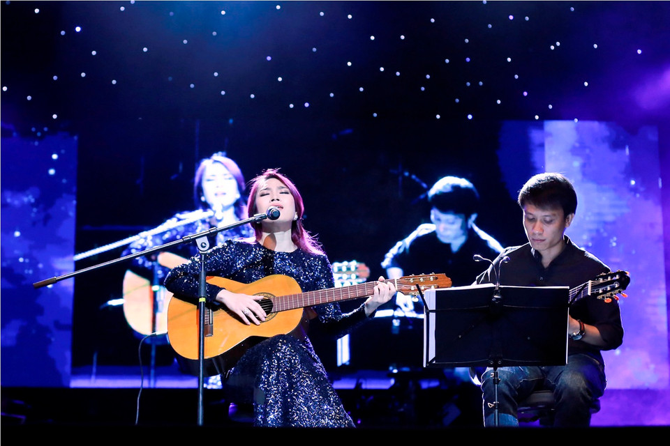 Ngoài những khắc sôi động, đêm nhạc có nhiều khoảng lặng của Mỹ Tâm khi cô ôm cây đàn guitar... (Ảnh: Tú Nguyễn)