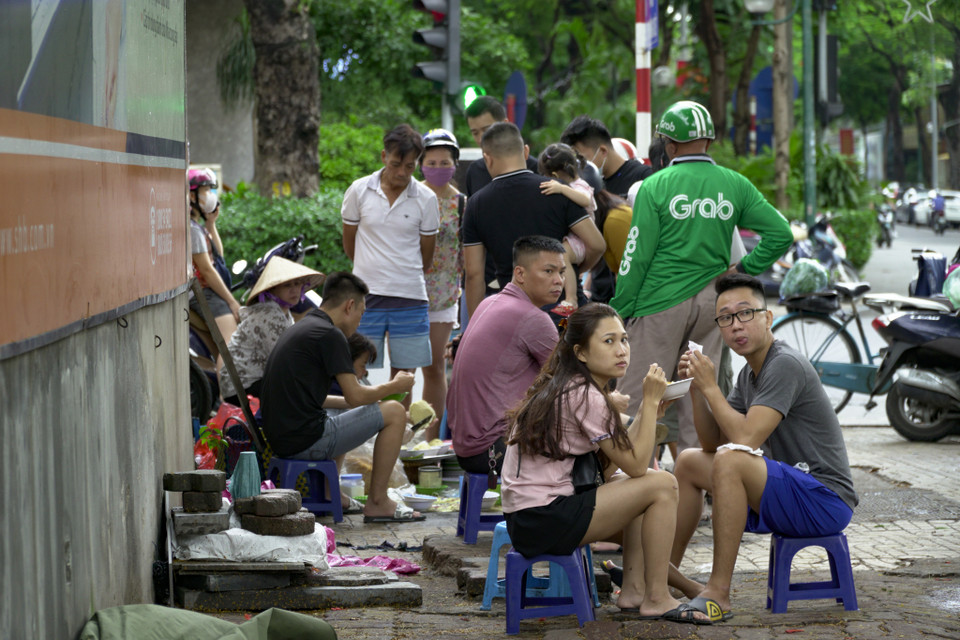 Người dân vẫn vô tư ngồi ăn đông đúc trên vỉa hè, lề đường. (Ảnh: Minh Hiếu/Vietnam+)