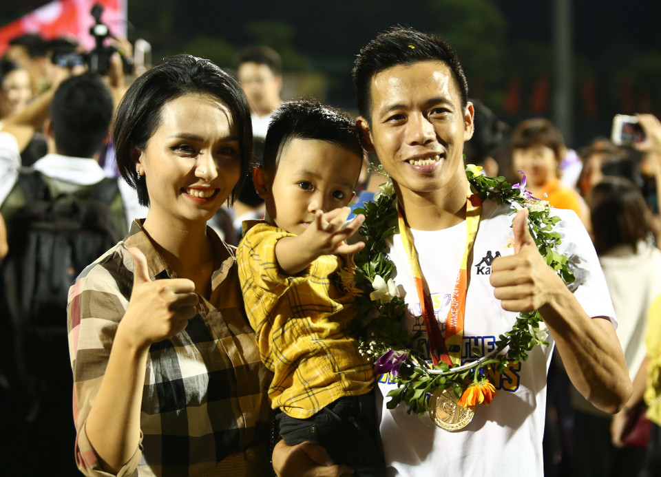 Tiền đạo Văn Quyết ăn mừng rạng rỡ chức vô địch cùng vợ và con trai. Cầu thủ này góp công lớn vào thành công của đội bóng khi chơi xuất sắc ở giai đoạn lượt về. (Ảnh: Nguyên An)