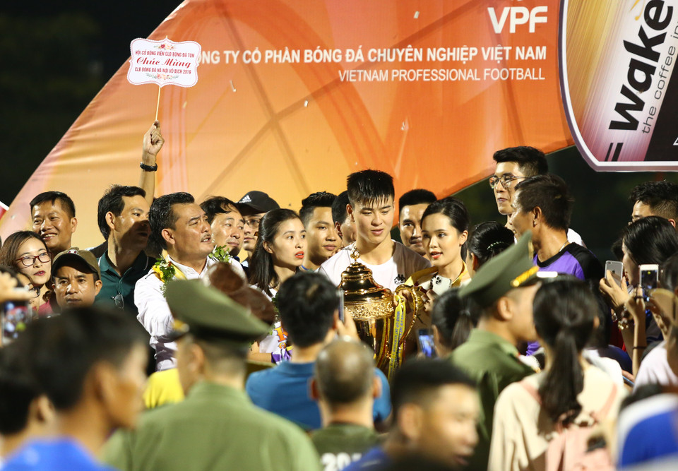 Người hâm mộ vây kín trung vệ Duy Mạnh cùng chiếc cúp vô địch. (Ảnh: Nguyên An)