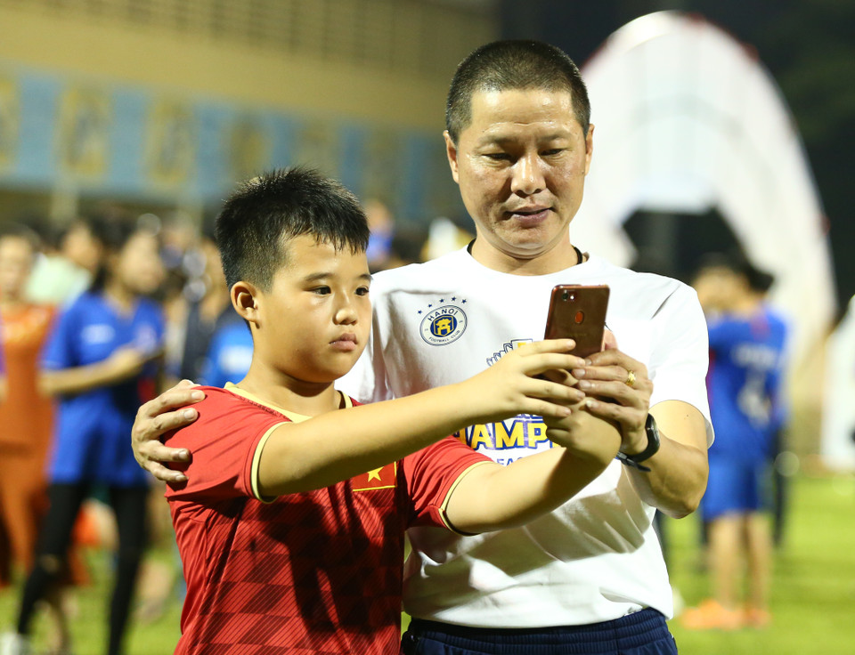 Huấn luyện viên Chu Đình Nghiêm chia vui cùng người hâm mộ nhí. (Ảnh: Nguyên An)