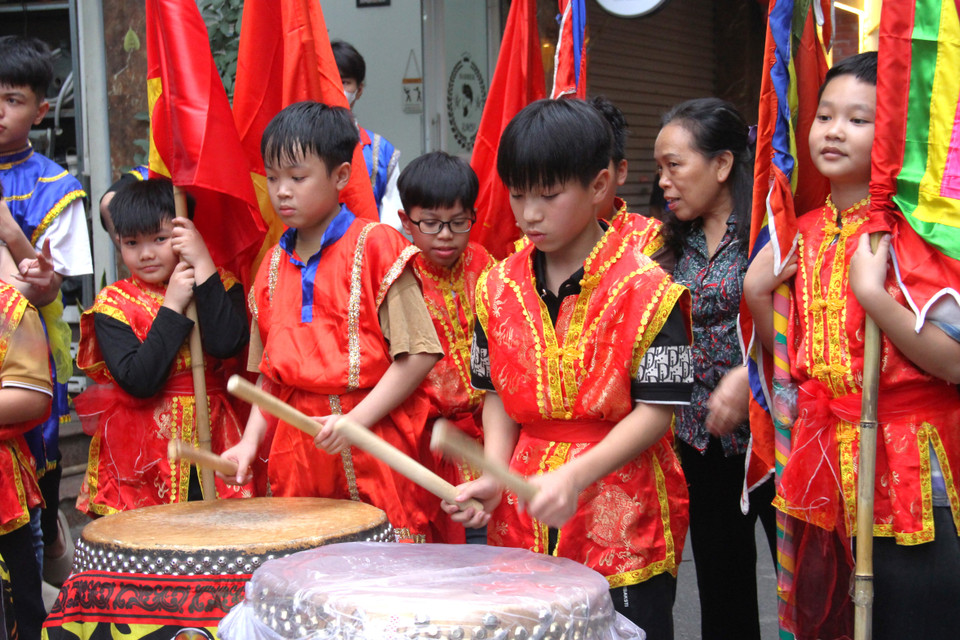 Các em nhỏ cũng được mặc những trang phục đầy màu sắc, đánh trống, phất cờ theo đoàn rước "ông lợn". (Ảnh: Hồng Ngọc/Vietnam+)