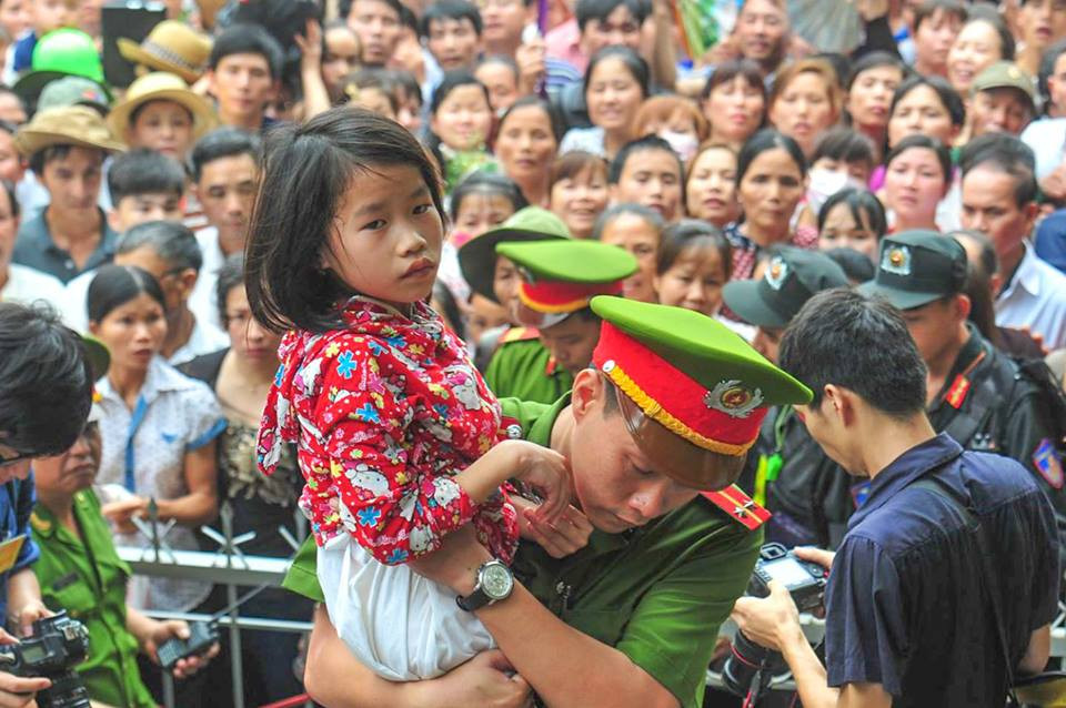 Dòng người mỗi lúc một đông, do phải chờ đợi quá lâu nên nhiều em bé tỏ ra mệt mỏi. Lực lượng an ninh phải ưu tiên cho các em vào khu vực phía trong rào chắn, tránh trường hợp chen lấn xô đẩy làm ảnh hưởng đến các em. (Ảnh: Minh Sơn/Vietnam+)