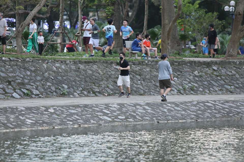 Tình trạng này cũng được ghi nhận tương tự bại bờ hồ Thành Công (Đống Đa) ở buổi sáng và chiều 30/3. Mọi người với nhiều lứa tuổi chủ yếu tới khu vực công cộng để chạy hoặc đi bộ. (Ảnh: Nguyên An/Vietnam+) 