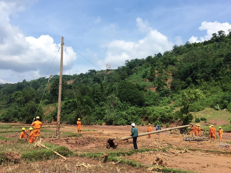 Giám đốc Điện lực Khe Sanh Phan Gia Dương (áo xanh) cho biết: Đường đã bị trôi thành suối, song, mưa vẫn lác đác nhỏ nên công nhân di chuyển rất khó khăn, đi bộ cũng hết 4 tiếng mới vào đến nơi. Nếu phải bê vác thì thời gian lên gấp đôi. (Ảnh: Thủy Trần/Vietnam+)