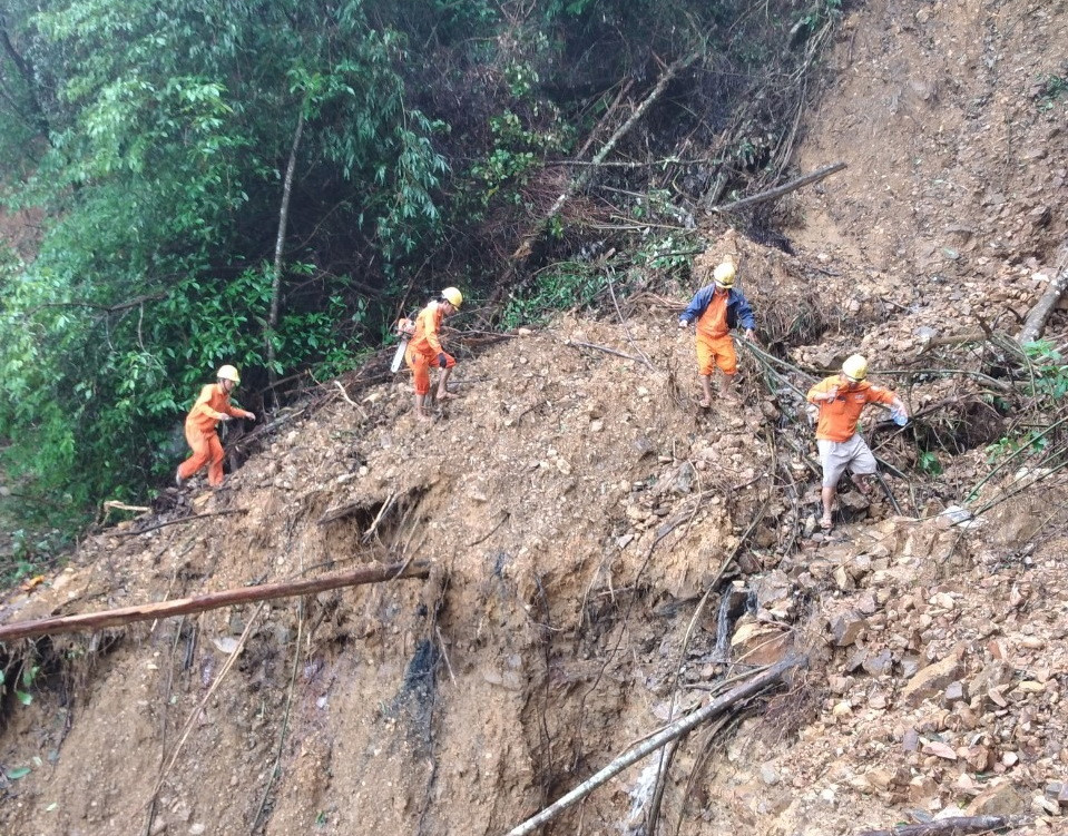 Để làm lại các đường điện cho Hướng Sơn, các cán bộ công nhân Điện lực Khe Sanh phải khiêng vác cột điện, dây cáp băng rừng, lội suối (Ảnh: Thủy Trần/Vietnam+)