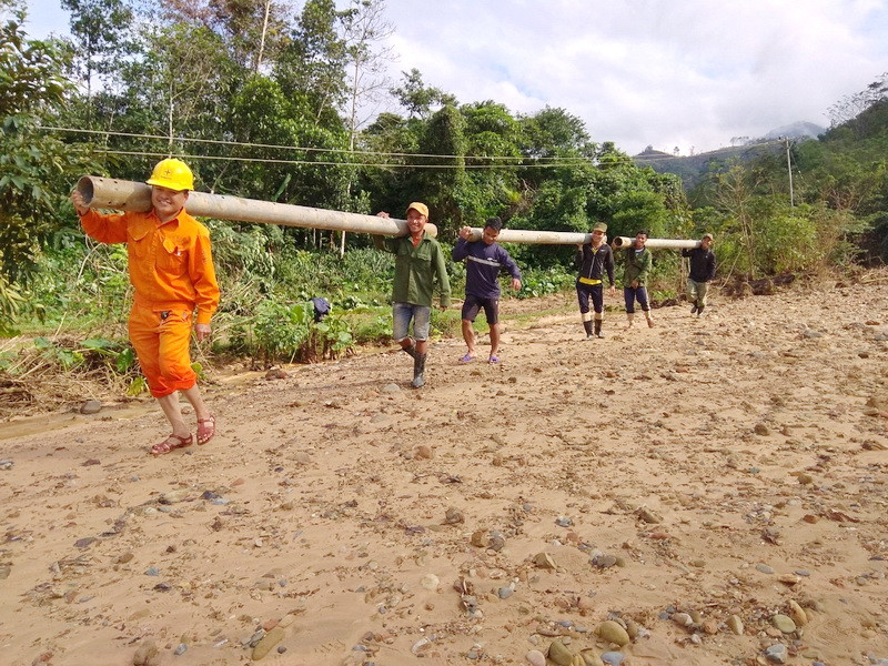 Mặc dù phải thau nhau cùi đồ, vác cột, kéo cáp leo đèo, lội suối nhưng nụ cười vẫn rạng rỡ trên khuôn mặt những người công nhân trẻ. (Ảnh: Thủy Trần/Vietnam+)