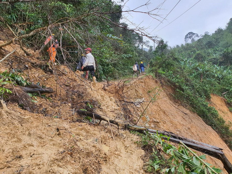 Vừa vác cột, cáp vừa phải dọn đường tìm lối đi (Ảnh: Thủy Trần/Vietnam+)
