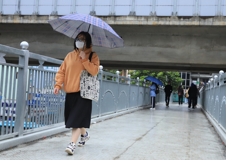 Nhiều người đã mặc thêm quần áo ấm khi nhiệt độ giảm mạnh. (Ảnh: Hoài Nam/Vietnam+)