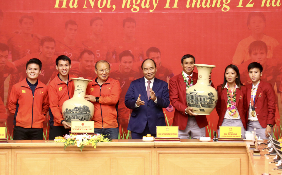 Thủ tướng Chính phủ Nguyễn Xuân Phúc trao tặng bình gốm quý cho hai đội tuyển bóng đá Việt Nam vừa giành huy chương Vàng SEA Games 30. (Ảnh: Nguyên An/Vietnam+)