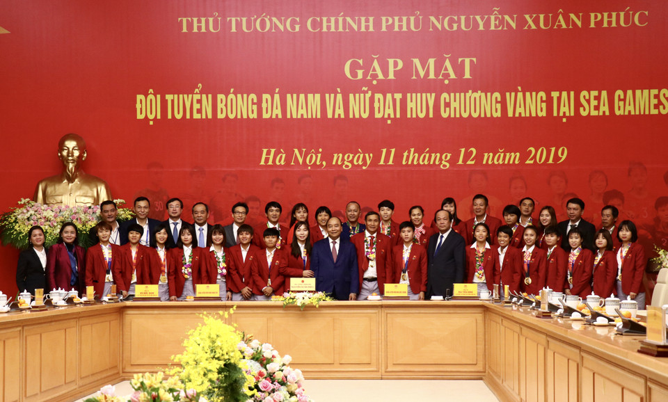 Thủ tướng Nguyễn Xuân Phúc chụp ảnh lưu niệm cùng đội tuyển nữ Việt Nam. (Ảnh: Nguyên An/Vietnam+)