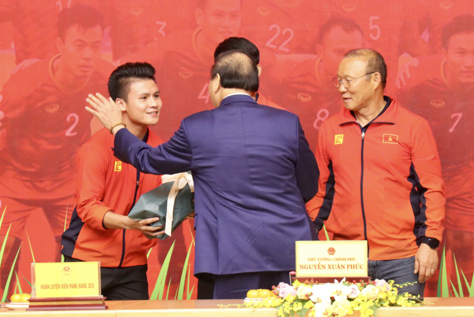 Tiền vệ Quang Hải vinh dự nhận hoa từ Thủ tướng và được động viên tiếp tục cố gắng cống hiến. (Ảnh: Nguyên An/Vietnam+)
