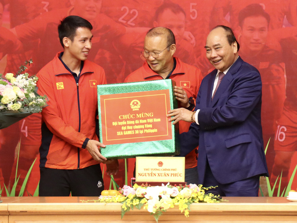 Tiếp đến, Thủ tướng trao tặng phần quà giá trị dành cho cả hai đội tuyển vừa giành thành tích cao. (Ảnh: Nguyên An/Vietnam+)