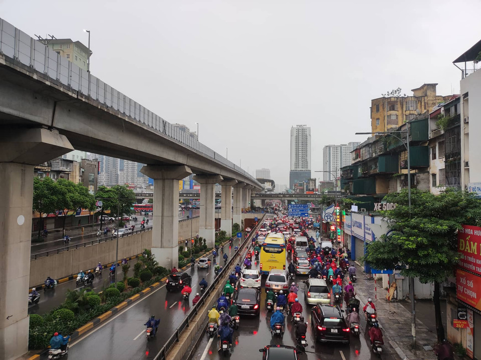 Cơn mưa dai dẳng kéo dài trong buổi sáng khiến các phương tiện giao thông di chuyển khó khăn. (Ảnh: PV/Vietnam+)