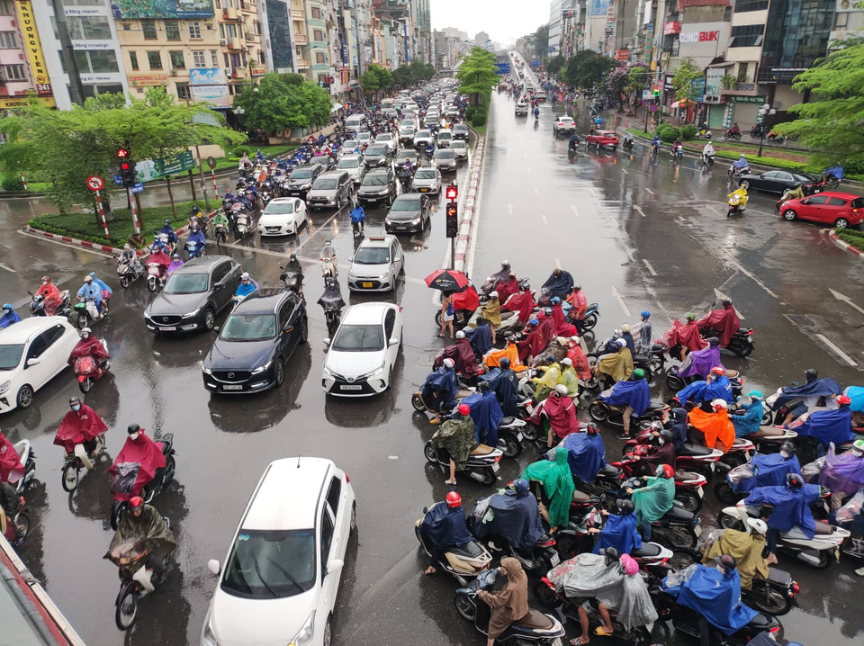 Người dân tại khu vực đường Trường Chinh di chuyển khó khăn trong cơn mưa lớn ngày đầu tuần. (Ảnh: PV/Vietnam+)