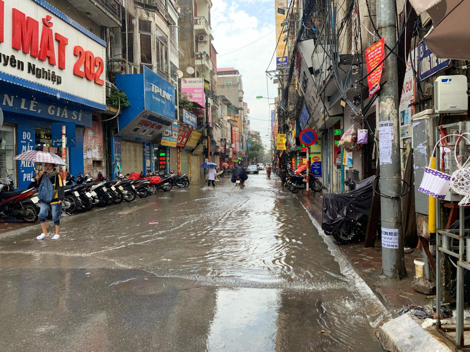 Mưa ngập trên con phố Lương Thế Vinh (Thanh Xuân, Hà Nội) khiến nhiều người đi lại khó khăn. (Ảnh: PV/Vietnam+)