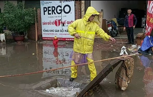 Nhân viên thoát nước đã phải mở cống để xả nước tránh ngập úng. (Ảnh: PV/Vietnam+)