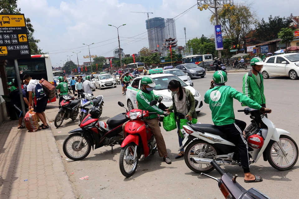 Dịch vụ xe ôm Grab đón khách tại khu vực bến xe Nước Ngầm. (Nguồn: Danh Lam/TTXVN)