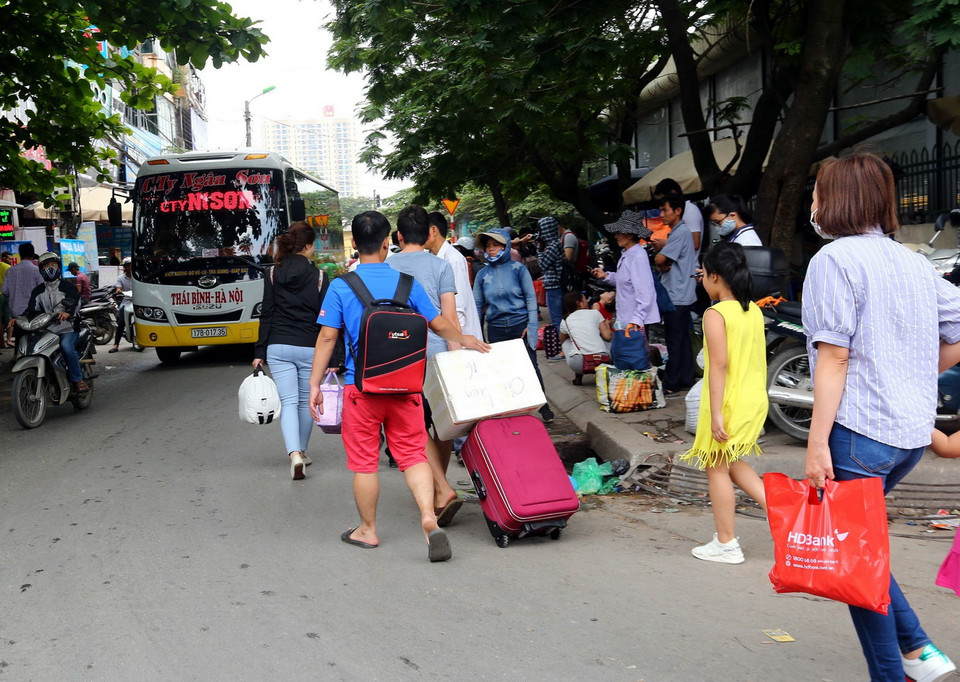 Người dân từ các tỉnh trở về thủ đô Hà Nội tại bến xe Giáp Bát. (Nguồn: Danh Lam/TTXVN)