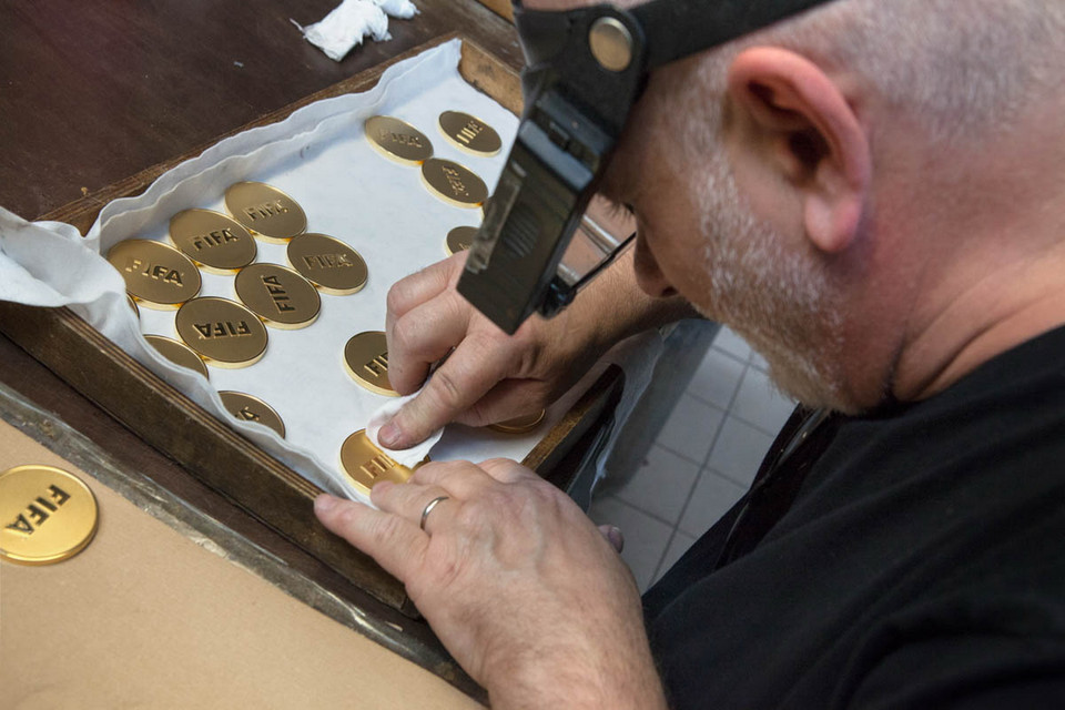 Nhà sản xuất kiểm tra và làm sạch huy chương bằng cồn. (Nguồn: Al-Jazeera)