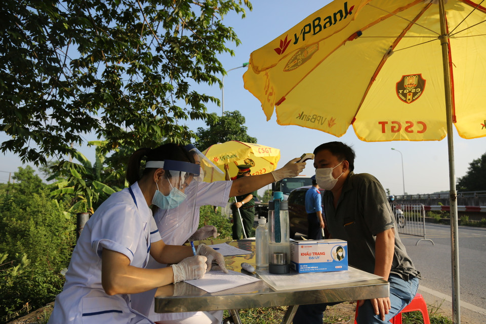 Đội ngũ y tế sẽ trực tiếp kiểm tra và yêu cầu mọi người khai báo đầy đủ điểm đi và đến, thông tin cá nhân, tình trạng sức khỏe gần nhất. (Ảnh: Hiển Nguyễn/Vietnam+)