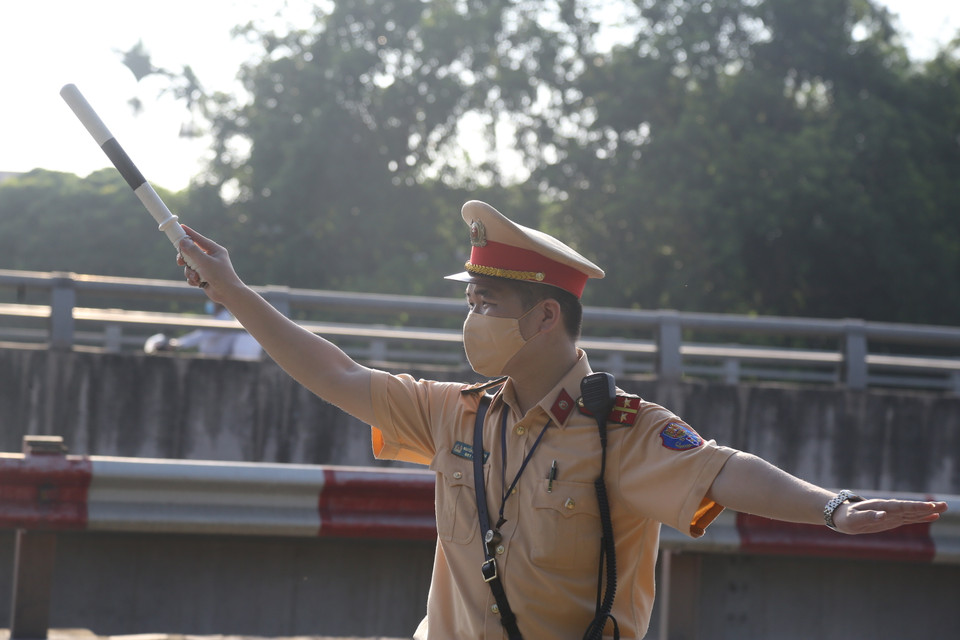 Chiến sỹ cảnh sát giao thông sẽ tiến hành chọn lọc các xe và yêu cầu đỗ lại để kiểm tra tại chốt. Tổ công tác ưu tiên kiểm tra các xe chở số lượng người lớn di chuyển từ các tỉnh thành về Hà Nội, đặc biệt kiểm tra các xe vận tải người như taxi, xe khách... (Ảnh: Hiển Nguyễn/Vietnam+)