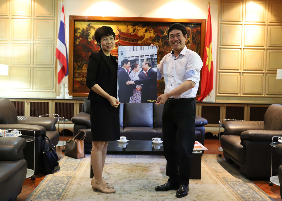 Phó Tổng giám đốc TTXVN Vũ Việt Trang tặng quà lưu niệm là tác phẩm ảnh của phóng viên TTXVN cho Đại sứ Việt Nam tại Thái Lan Nguyễn Hải Bằng. (Ảnh: Ngọc Quang-Hữu Kiên/TTXVN)