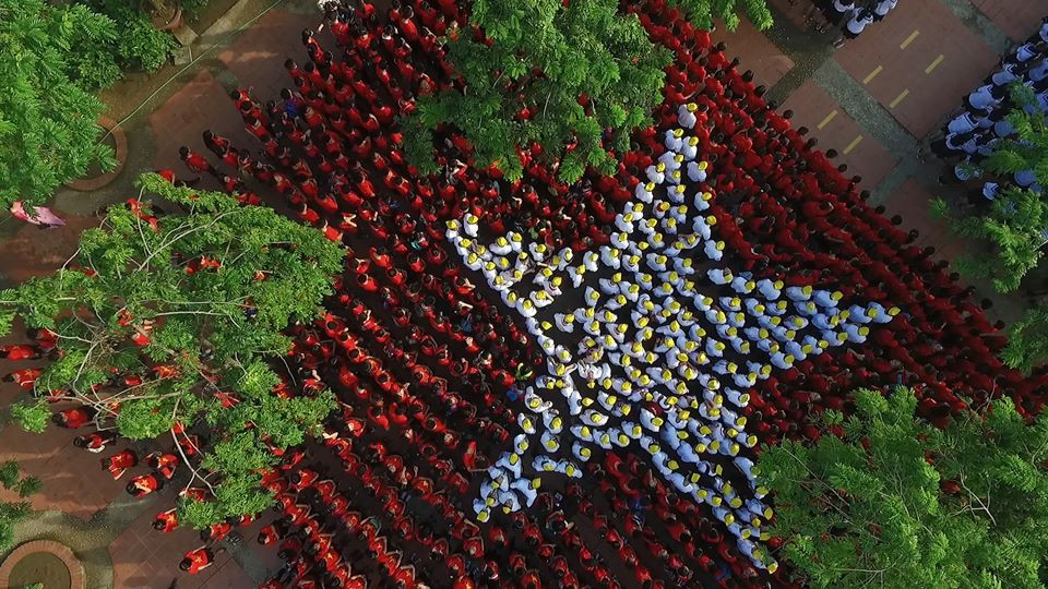 Nhập mô tả Các khối học sinh còn lại với trang phục đỏ xếp thành phần nền đỏ của lá cờ Tổ quốc. (Ảnh: Phan Hải Tùng Lâm/Vietnam+)cho ảnh