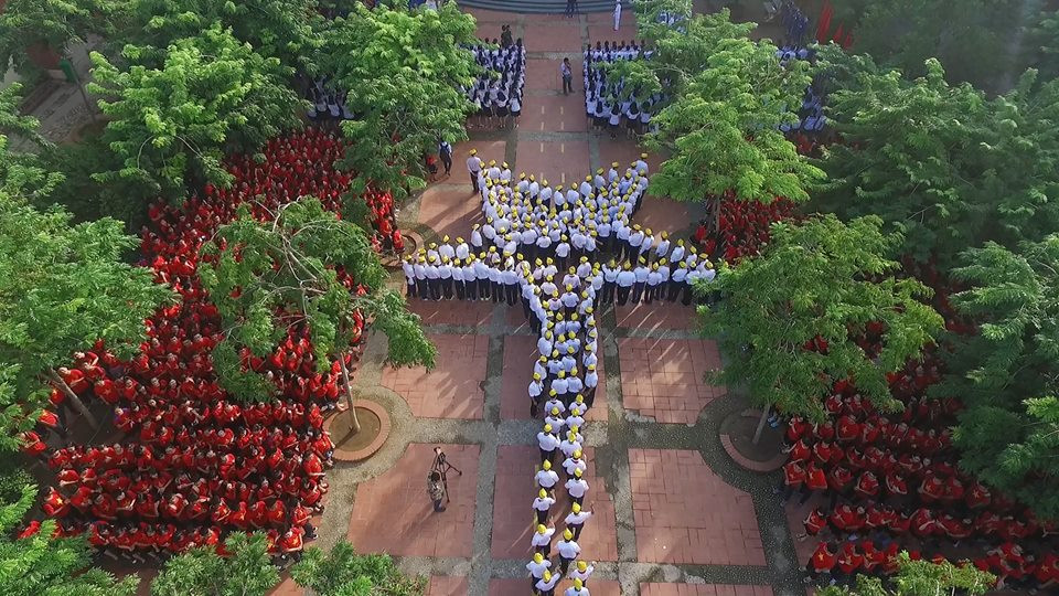 Các khối học sinh mới tiến vào sân, xếp thành hình ngôi sao vàng ở trung tâm. (Ảnh: Phan Hải Tùng Lâm/Vietnam+)