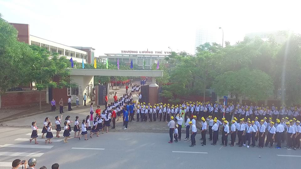 7h 30 buổi lễ khai giảng mới bắt đầu, nhưng các bậc phụ huynh đã đưa con em Học sinh của các khối mới vào trường như khối 6 và khối 10, xếp thành các hàng dọc ở cổng trường, nối đuôi nhau tiến vào khu vực sân trong. (Ảnh: Phan Hải Tùng Lâm/Vietnam+)