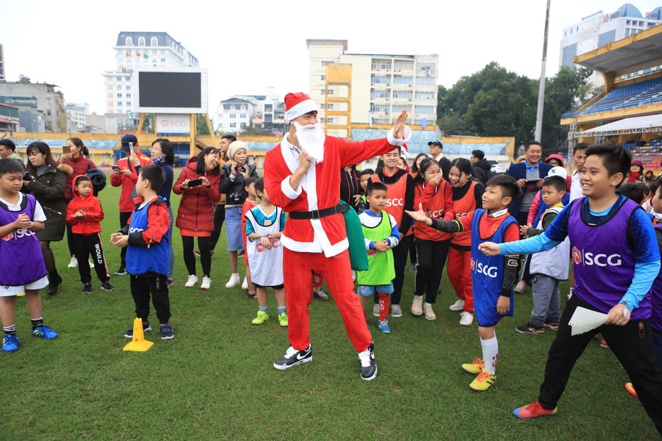 Trung vệ Đỗ Duy Mạnh được rất đông người hâm mộ nhí vây kín trong khi tặng quà. (Ảnh: Vietnam+)