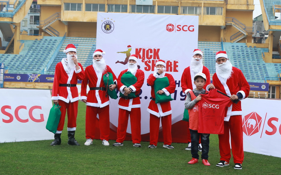 Tiền vệ Văn Quyết tặng áo đấu có chữ ký của các cầu thủ Hà Nội FC cho em nhỏ đặc biệt có ước mơ bóng đá cháy bỏng, mong một ngày trở thành tuyển thủ quốc gia. (Ảnh: Vietnam+)