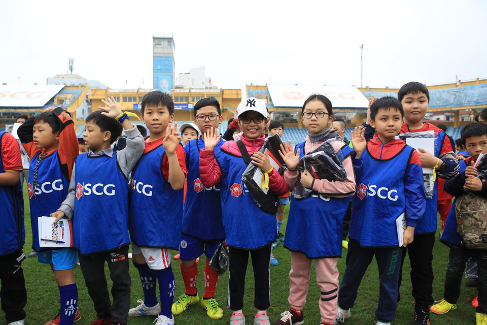 Các em nhỏ tỏ ra hưng thú với phần quà nhận được từ những 'ông già Noel' đặc biệt. Có nhiều em ở tỉnh xa đã phải dậy rất sớm trong thời tiết lạnh buốt để di chuyển tới Hà Nội gặp gỡ cầu thủ mình yêu thích. (Ảnh: Vietnam+)