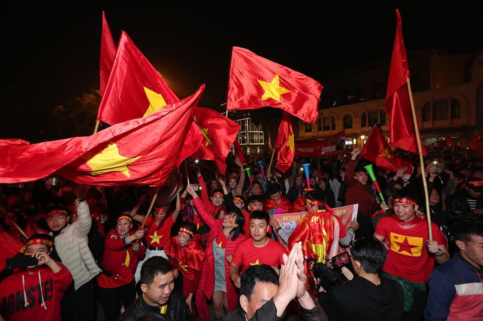 Rất nhiều cờ đỏ sao vàng được người hâm mộ tung bay ngoài đường. (Ảnh: Minh Sơn/Vietnam+)