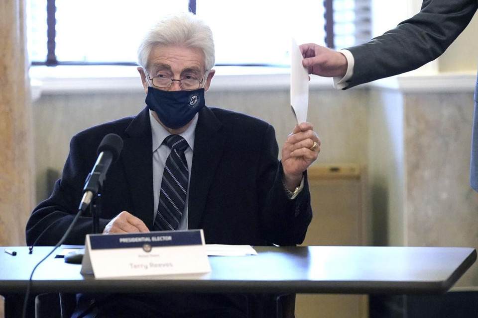 Đại cử tri trao phiếu cho nhân viên xác nhận. (Ảnh: AP)